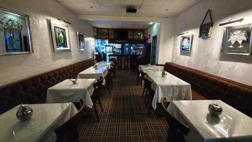 uma sala de jantar com mesas e cadeiras num restaurante em RockDene em Blackpool