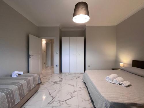 two beds in a bedroom with marble flooring at Kalos Casa Vacanza in Salice Salentino