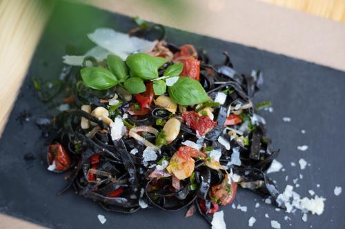 a black plate with a salad on a table at Joy Aparthotel Keilberg in Klínovec