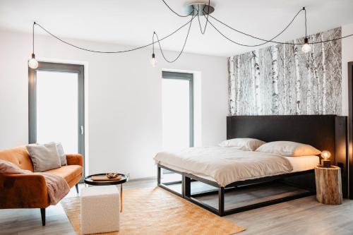 a bedroom with a bed and a chair at Joy Aparthotel Keilberg in Klínovec
