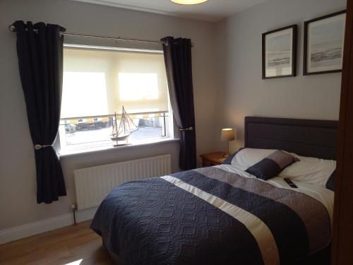a bedroom with a bed and a large window at Sea Crest B&B Rossnowlagh in Rossnowlagh