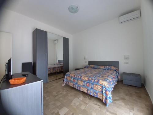 a bedroom with a bed and a dresser and a mirror at B&B La Vela in Villa Rosa