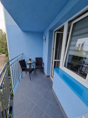 Apartament blisko morza Carmen في كولوبرزيغ: مبنى أزرق مع شرفة مع طاولة وكراسي