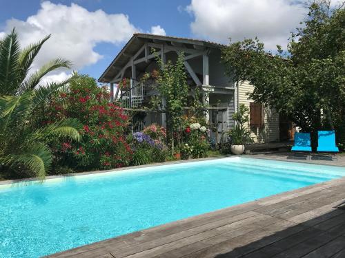 a swimming pool in front of a house at Les Arums de Fondeminjean in Vertheuil-en-Médoc