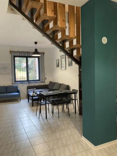 sala de estar con mesa, sillas y pared verde en Zöldike Vendégház, en Tiszafüred