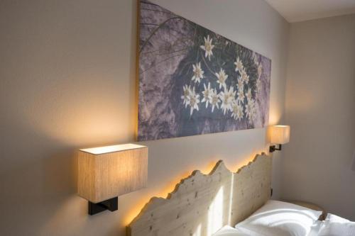 una camera da letto con un dipinto a fiori sul muro di Agritur Piccolo Fiore B&B a Taio