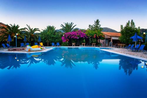 a swimming pool with a person laying on a raft in the water at Efrosini Village in Katelios