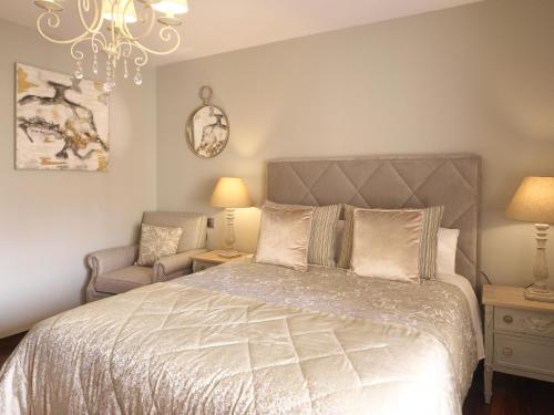 una camera da letto con un letto, una sedia e un lampadario di El Mirador de Begoña - VUT-606-AS a Gijón