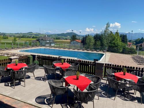 a patio with tables and chairs and a swimming pool at Hotel Lohninger-Schober 3 Stern Superior in Sankt Georgen im Attergau