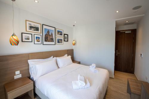 a bedroom with a large white bed and a table at Bliss Boutique Living in Xagħra