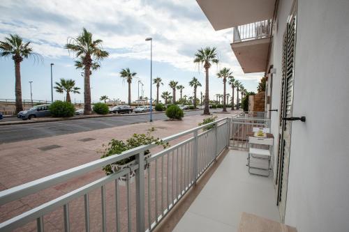 a balcony with a view of a street with palm trees at Casa Timone in San Leone