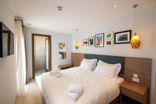 a bedroom with a large bed with two towels on it at Bliss Boutique Living in Xagħra