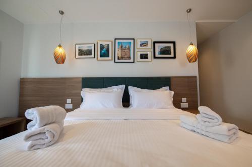 a bedroom with two beds with white towels on them at Bliss Boutique Living in Xagħra