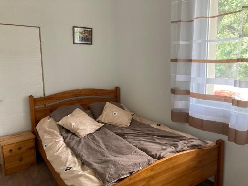 un letto non rifatto in una camera da letto con finestra di Salvus Panzió a Bükkszék