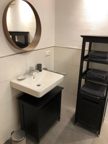 ein Bad mit einem Waschbecken und einem Spiegel in der Unterkunft Modernes Apartment in Gondelsheim