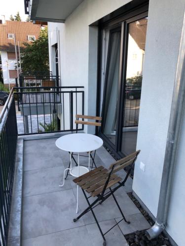 einen Tisch und einen Stuhl auf dem Balkon in der Unterkunft Modernes Apartment in Gondelsheim