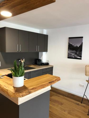 a kitchen with black cabinets and a wooden counter top at Modernes Apartment in Gondelsheim