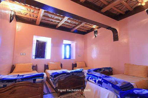a room with three beds in a room with a ceiling at Tigmi Tachddirt in Tacheddirt