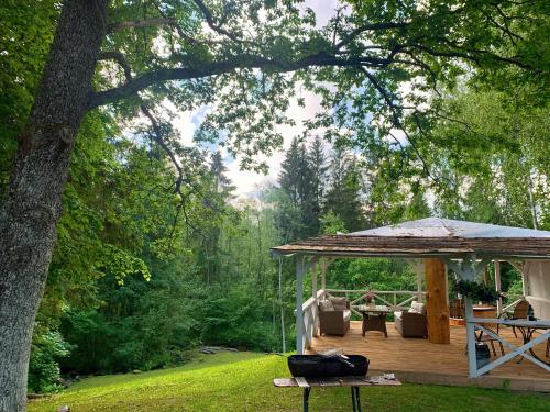 a wooden deck with a gazebo in a yard at Vana-Vastseliina külalistemaja in Illi
