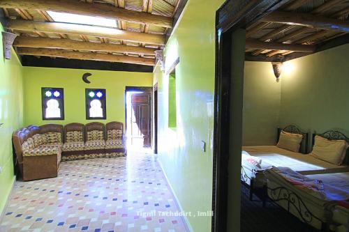 a room with two beds and chairs in it at Tigmi Tachddirt in Tacheddirt