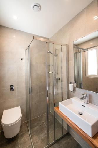 a bathroom with a sink and a toilet and a shower at Bliss Boutique Living in Xagħra
