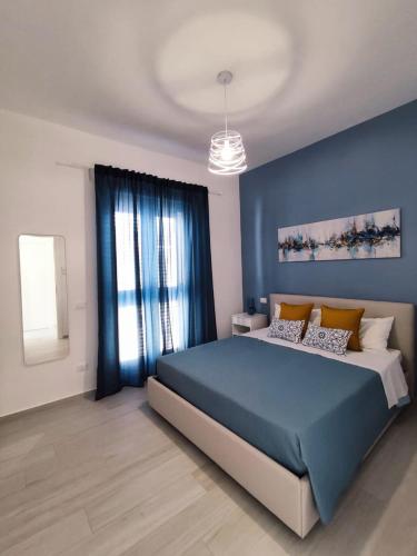 a bedroom with a blue bed and a window at White Wall luxury rooms Scala dei turchi in Realmonte