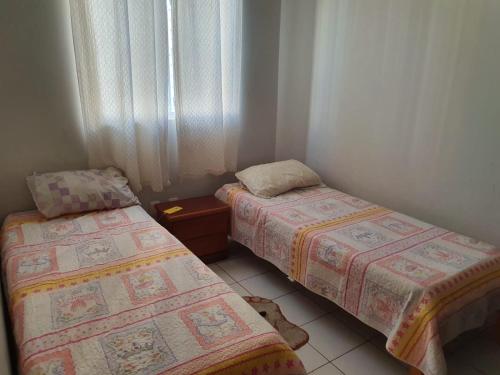 two twin beds in a room with a window at Apartamento Millenium Otima Localizacao E Nova Area DE Lazer!!! in Caldas Novas