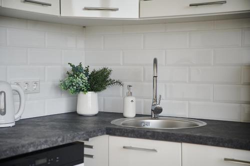 a kitchen counter with a sink and flowers on it at Freshly renovated family apartment in Kuressaare