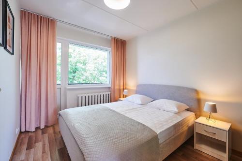Un dormitorio con una cama grande y una ventana en Freshly renovated family apartment, en Kuressaare