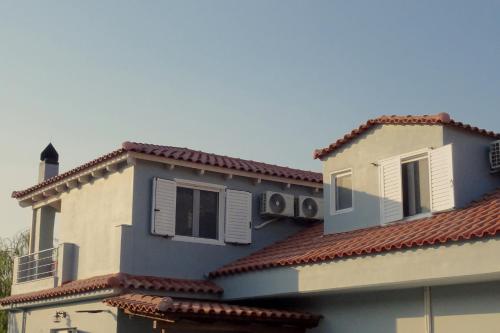 a building with red tile roofs and white windows at Vasiliki Residence in Pylos
