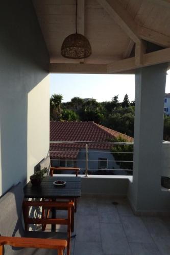 a patio with a table and chairs and a large window at Vasiliki Residence in Pylos