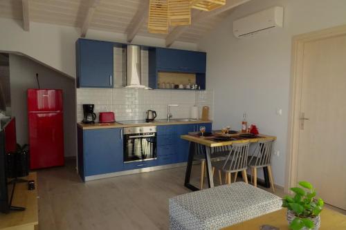 a kitchen with blue cabinets and a red refrigerator at Vasiliki Residence in Pylos