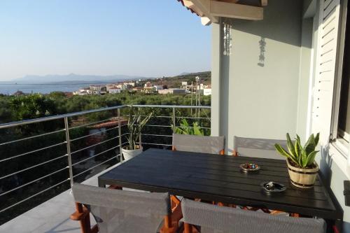 a table on a balcony with a view of the ocean at Vasiliki Residence in Pylos
