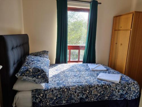 Schlafzimmer mit einem Bett und einem Fenster mit grünen Vorhängen in der Unterkunft Carnarvon Street City Centre Apartment in Glasgow