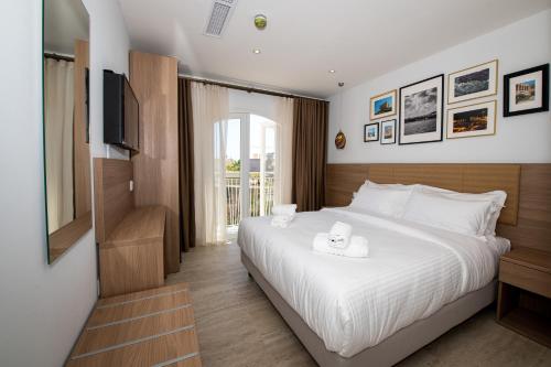 a bedroom with a bed with a television and a bed sidx sidx sidx at Bliss Boutique Living in Xagħra