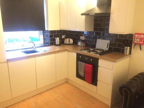 a kitchen with white cabinets and a stove top oven at Stafford apartments in Stafford