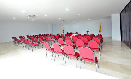 a large room with red chairs and a podium in it at Hotel Suite Continental in Barranquilla
