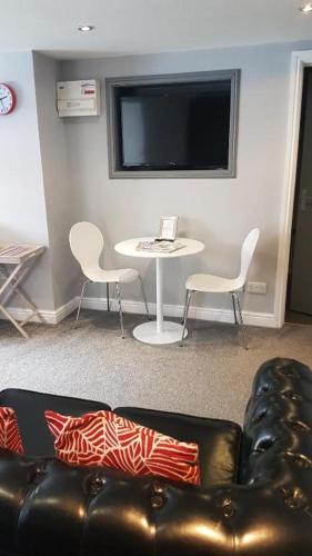 a living room with a couch and a table and a tv at Stafford apartments in Stafford