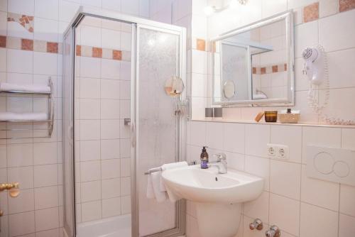 a white bathroom with a sink and a shower at Landpension Birnthaler in Kallmünz