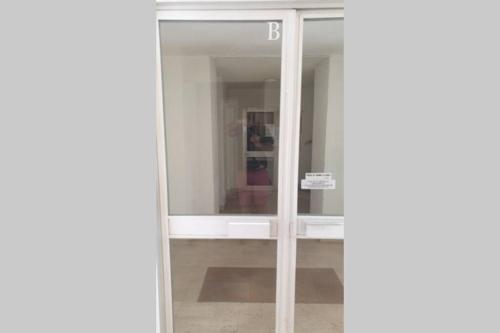 une porte en verre menant à une chambre avec un canapé rouge dans l'établissement AiguesMarines, à Cagnes-sur-Mer