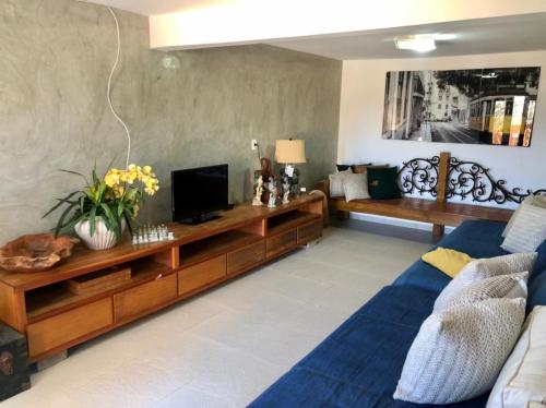 Una sala de estar con un sofá y un televisor. en Casa aconchegante com piscina em Tiradentes, en Tiradentes