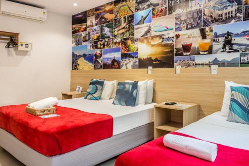 2 camas en una habitación con fotos en la pared en Injoy Suítes & Aparts en Río de Janeiro