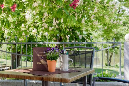 a table with a book and a vase with purple flowers at Landpension Birnthaler in Kallmünz