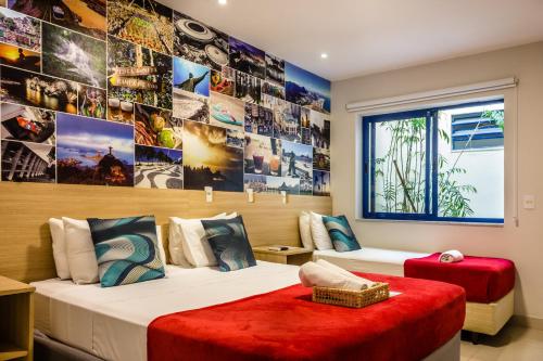 two beds in a room with pictures on the wall at Injoy Suítes & Aparts in Rio de Janeiro