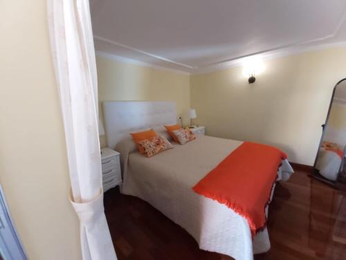 1 dormitorio con cama blanca y manta naranja en Camino Real en Barranco Hondo