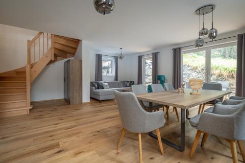 トゥルラッハー・ヘーエにあるMy Turrach Grünsee Chalet by S4Yのテーブルと椅子のあるダイニングルームとリビングルーム