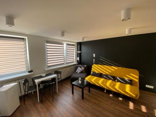 salon z żółtą kanapą i stołem w obiekcie Apartamenty Czapla w mieście Mikołajki
