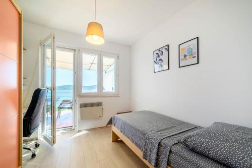 ein Schlafzimmer mit einem Bett und einem Fenster in der Unterkunft Apartment Seaside in Zaboric