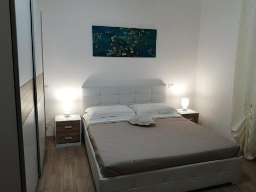 1 dormitorio con 1 cama, 2 lámparas y una pintura en Due Magnolie, en Monzambano