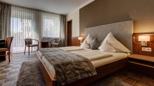 a hotel room with a large bed in a room at Hotel Restaurant Weihenstephaner Stuben in Landshut